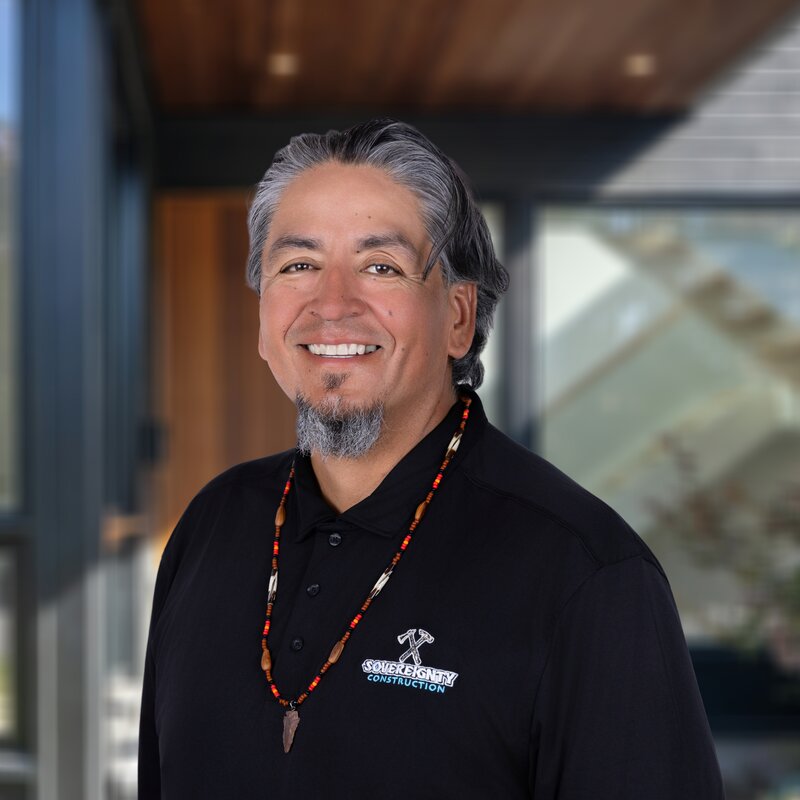 Headshot of Anthony Smith, Construction Superintendent at Sovereignty Construction, wearing a branded polo and beaded necklace.